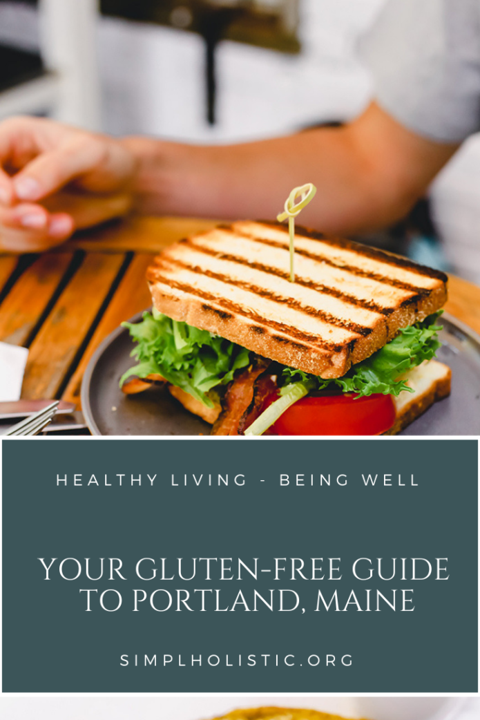 Your gluten free guide to Portland Maine in text over a dark blue box with white words. The background is a picture of a grilled sandwich with tomato and greens portland maine gluten free