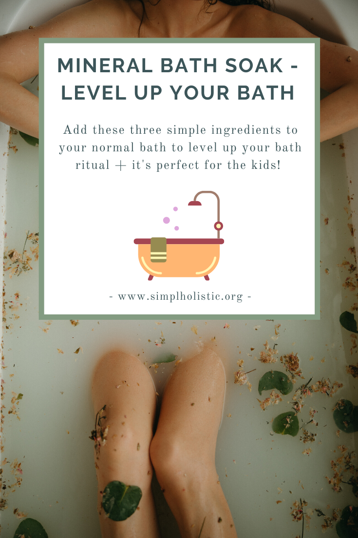 photo of a ladies legs in a bath with leaves and flowers and milky water with the text mineral bath soak - level up your bath